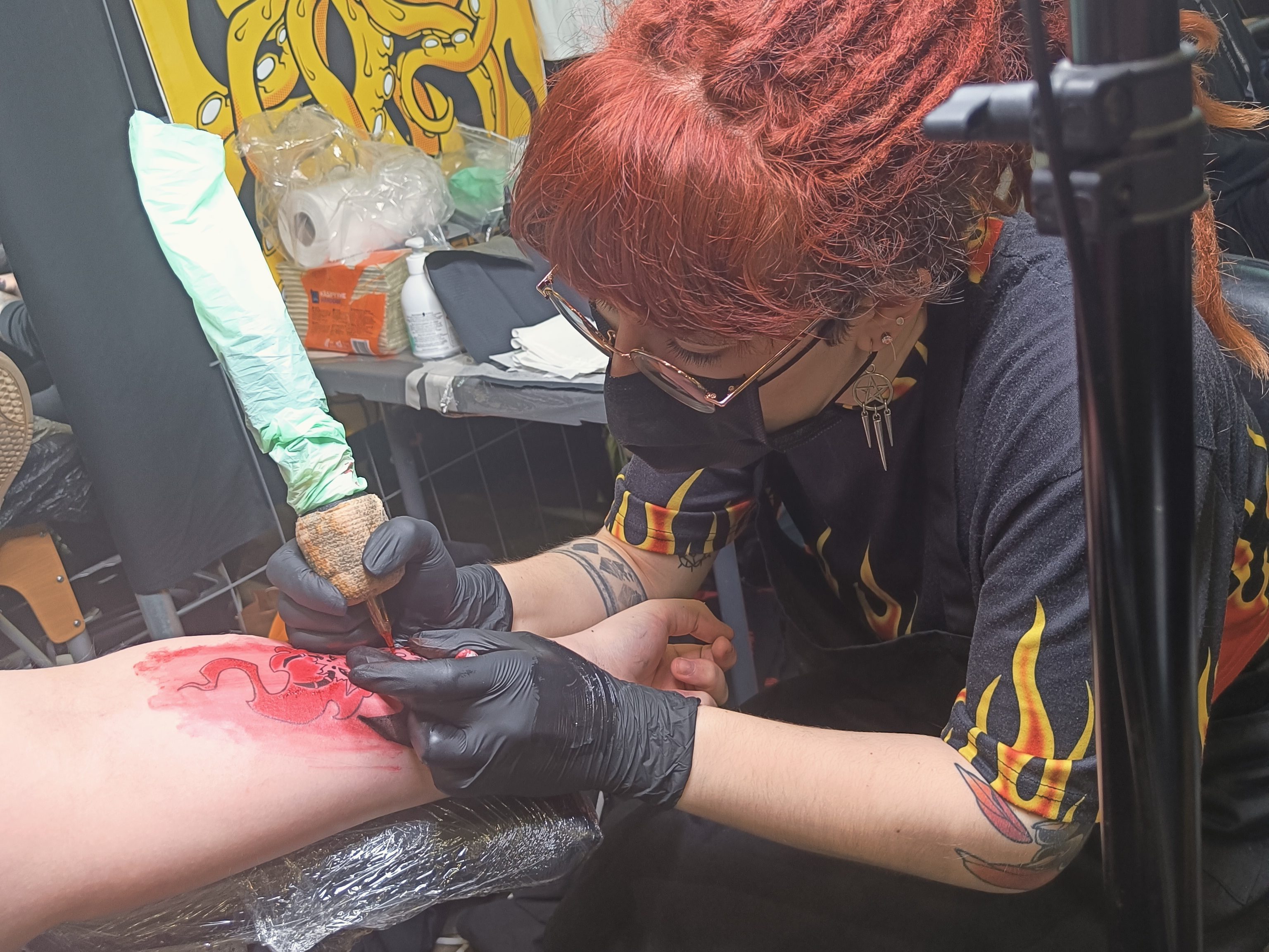 Noora tattooing on a client at a fest