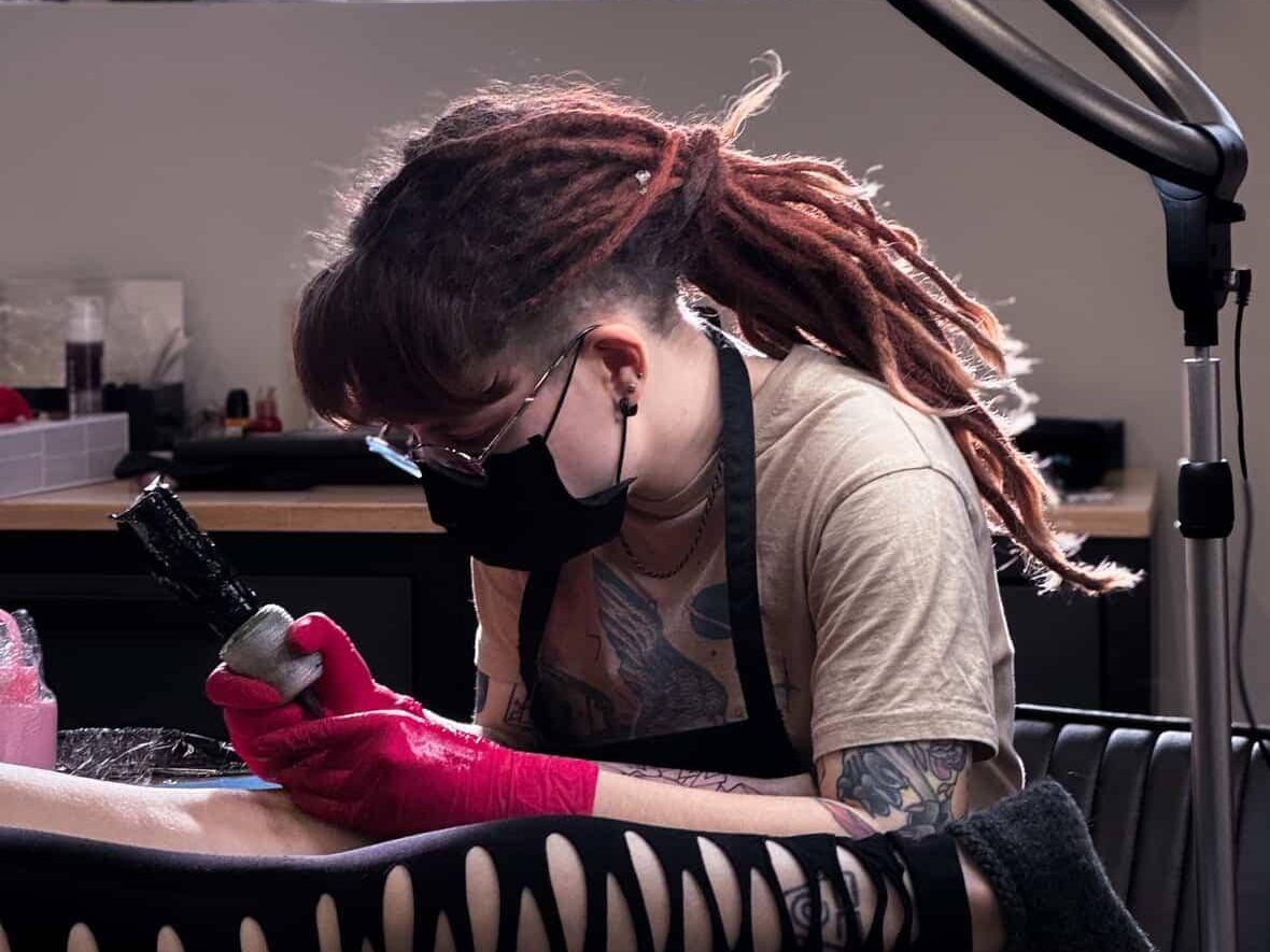 Noora tattooing a client at a studio